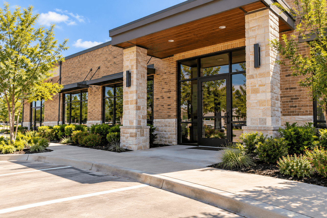 Brick commercial building with a clean entrance and maintained landscaping.